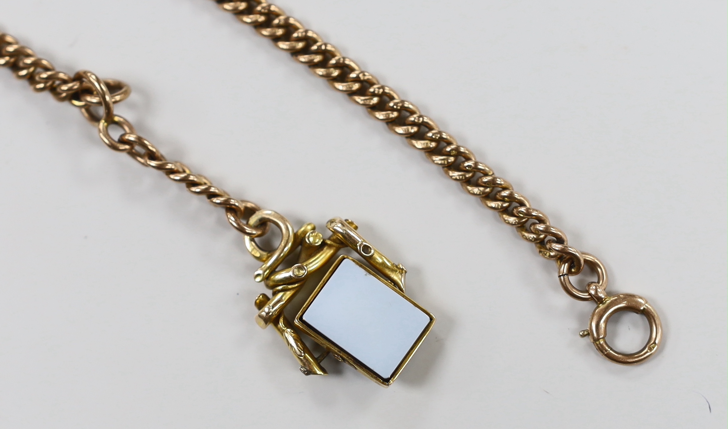 An early 20th century 9ct gold curb link chain, 39cm, hung with an Austro Hungarian yellow metal and chalcedony set spinning fob, gross weight 47.1 grams.